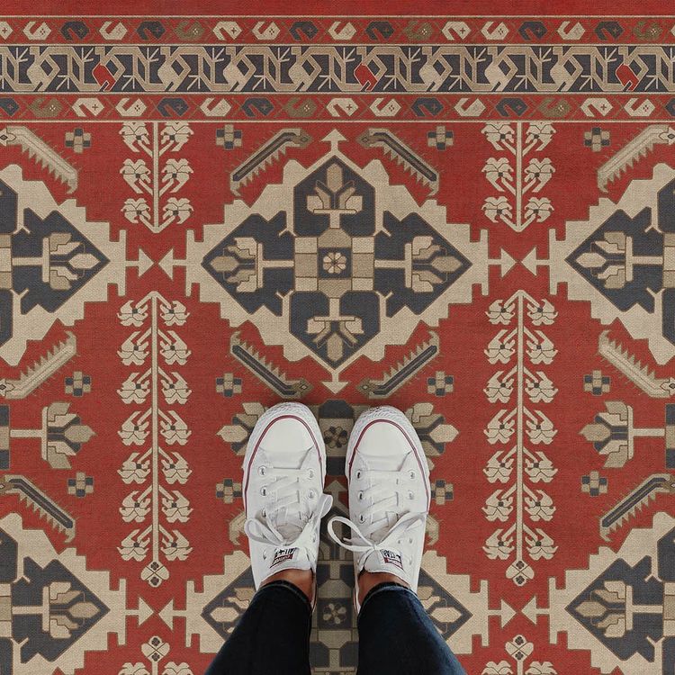 feet standing on red Persian bazaar rug
